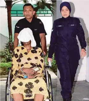  ?? PIC BY MOHD ASRI SAIFUDDIN MAMAT ?? Rose Achieng Ojala being led to the Shah Alam High Court yesterday.