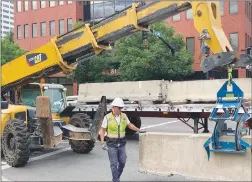  ?? Tribune News Service ?? A worker places a concrete barrier in Portland on Friday to control crowds at a face-off expected between far-right groups and antifa counter-protesters. Police closed off streets and a downtown bridge early on Saturday in Oregon’s largest city.