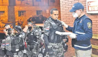  ??  ?? Un agente policial de Criminalís­tica somete al alcotest a otro que integra el Grupo Lince, en la comisaría 5ª de Asunción.