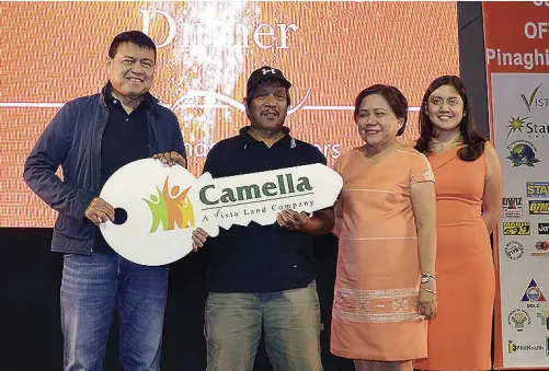  ??  ?? Former Senator Manny Villar, Sen. Cynthia Villar and Vista Land Director Camille Villar pose for a photo with OFW Edmundo Enguero after the latter wins a house and lot from Camella Homes during the summit