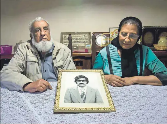  ??  ?? Truth: Ismail Haffejee and Sarah Lall with a portrait of their brother Hoosen Haffejee, who died in police custody in 1977. Photo: Rogan Ward