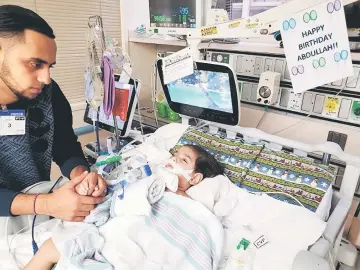  ??  ?? This photo courtesy of the Council on American-Islamic relations in Sacramento shows Abdullah on life support at UCSF Benioff Children’s Hospital in Oakland with his father, Ali. — AFP photo