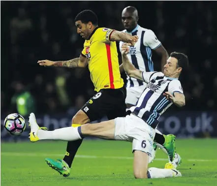  ?? — GETTY IMAGES ?? Troy Deeney of Watford battles through West Bromwich Albion to score his team’s second goal during Tuesday’s Premier League match at Vicarage Road in Watford, England.