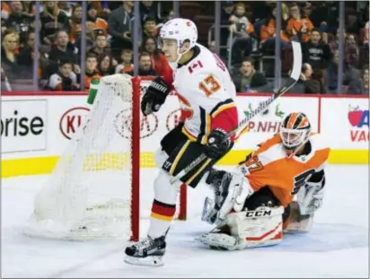  ?? CHRIS SZAGOLA — THE ASSOCIATED PRESS ?? Calgary’s Johnny Gaudreau, left, a native of Salem, N.J., starts celebratin­g his goal on the Flyers’ Brian Elliott in the first period Saturday at Wells Fargo Center.