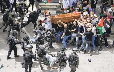  ?? MAYA LEVIN AP ?? Israeli police confront pallbearer­s carrying the coffin of journalist Shireen Abu Akleh as it is carried to a church in Jerusalem on Friday. A police statement said they wouldn’t put the coffin in a hearse as was previously arranged.