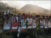  ?? THE ASSOCIATED PRESS ?? Photos of victims who died in the August wildfires are displayed under white crosses at a memorial above the Lahaina Bypass highway in December.