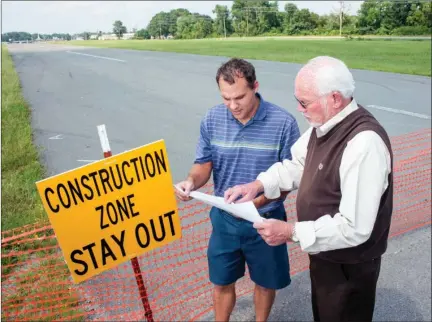  ?? WILLIAM HARVEY/TRILAKES EDITION ?? John Eckart, left, director of the Benton Parks and Recreation Department, looks at plans for the proposed Riverside Park, along with Benton Mayor David Mattingly. The park will convert property formerly utilized as the Saline County airport and...