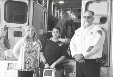  ?? COURTESY OF YRMC ?? TRI-VALLEY AMBULANCE SERVICE EMERGENCY MEDICAL technician Daniela Mendoza (center), and EMS Chief Richard
Nix, who is also a paramedic, accept a cardiac monitor from Jackie Woodwell, executive director of the Foundation of Yuma Regional Medical Center.