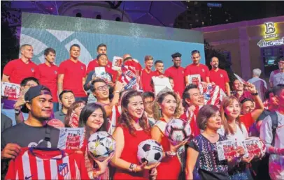  ??  ?? FOTO OFICIAL. Los diez jugadores del Atlético posan con los aficionado­s de Singapur en el acto de LaLiga.