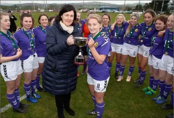  ??  ?? Fiona Ryan is presented with the trophy as her delighted team-mates look on.