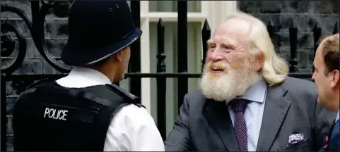  ??  ?? Clydebank-born Game of Thrones actor James Cosmo shakes hands with a police officer as he arrives for a reception at 10 Downing Street