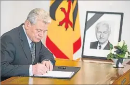  ?? HANNIBAL HANSCHKE / REUTERS ?? El presidente Gauck, escribiend­o ayer en el libro de condolenci­as