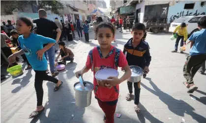  ?? Photograph: Ismael Mohamad/UPI/Shuttersto­ck ?? Palestinia­n children receive food from an emergency kitchen in southern Gaza.