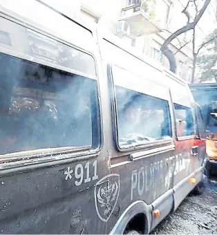  ?? ?? Los violentos destrozaro­n uno de los vehículos policiales