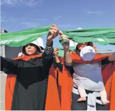  ??  ?? ► Activistas sostienen pañuelos verdes que simbolizan el movimiento a favor del aborto.