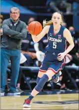  ?? GARY LANDERS/AP PHOTO ?? UConn guard Paige Bueckers heads up court in a game against Xavier as coach Geno Auriemma, left, looks on in Cincinnati on Feb. 20.