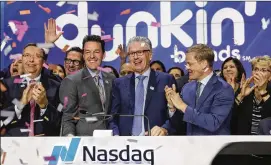  ?? MARK LENNIHAN / ASSOCIATED PRESS ?? Nigel Travis (center), CEO of Dunkin’ Brands, takes part in the opening bell ceremony at the Nasdaq Stock Exchange in New York. At left is David Hoffmann, president of Dunkin’ Donuts U.S. and Canada; at right is Nasdaq President Nelson Griggs. Canton,...