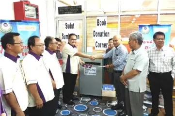  ??  ?? Sempurai (fifth left) and Abdul Rahman (third right) dropping books into a collection box during the launching of this year’s Book Campaign.