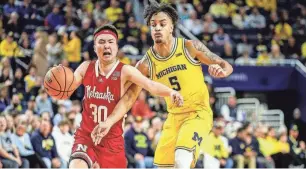  ?? JUNFU HAN/DETROIT FREE PRESS ?? Nebraska guard Keisei Tominaga is defended by Michigan forward Terrance Williams II during the first half at Crisler Center on Sunday.