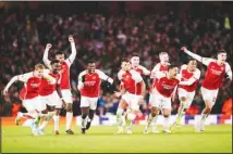  ?? ?? Arsenal players celebrate after winning the penalty shoot-out during the Champions League round of 16, second leg soccer match between Arsenal and Porto at the Emirates Stadium, London. (AP)