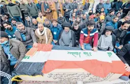  ?? ALI NAJAFI/GETTY-AFP ?? Mourners pray Thursday in Najaf, Iraq, over the coffin of a person killed in twin suicide bombings in Baghdad that left at least 32 dead and 110 wounded.