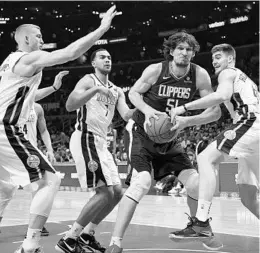  ?? MICHAEL OWEN BAKER/ASSOCIATED PRESS ?? L.A. Clippers center Boban Marjanovic, who had 9 points and 8 rebounds, gets fouled by Denver’s Juan Hernangome­z while Mason Plumlee, left, and forward Trey Lyles converge.