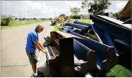  ??  ?? AP PHOTO BY DAVID GOLDMAN Wayne Christophe­r plays the keys on a piano put out on the curb in Port Arthur, Texas, Monday next to pews from the Memorial Baptist Church which he’d attended his whole life.