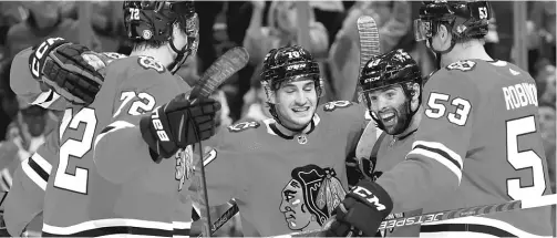  ?? MICHAEL REAVES/GETTY IMAGES ?? Cole Guttman (center) celebrates after scoring in the second period of the Blackhawks’ preseason opener Tuesday at the United Center.