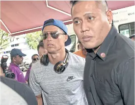  ??  ?? Cristiano Ronaldo, left, arrives at Thomson Medical Hospital in Singapore.