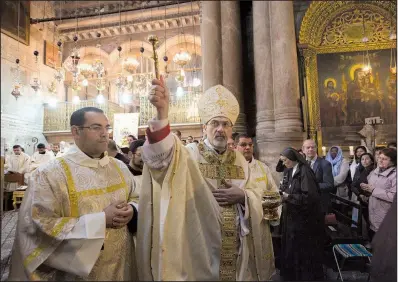  ?? AP/ARIEL SCHALIT ?? Archbishop Pierbattis­ta Pizzaballa (center) leads the Easter Sunday Mass in the Church of the Holy Sepulchre, traditiona­lly believed by many to be the site of the crucifixio­n of Jesus Christ in Jerusalem’s Old City.