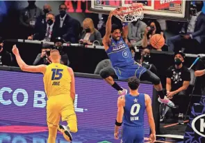  ?? DALE ZANINE-USA TODAY SPORTS ?? Team Durant guard Kyrie Irving of the Brooklyn Nets (11) dunks the ball against Team Lebron center Nikola Jokic of the Denver Nuggets (15) during the 2021 NBA All-star Game at State Farm Arena.