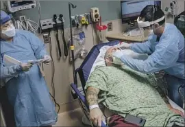  ?? Marcus Yam Los Angeles Times ?? NURSE ARNOLD GARCIA collects a testing sample from a patient admitted with possible COVID-19 symptoms at Sharp Chula Vista Medical Center in April.