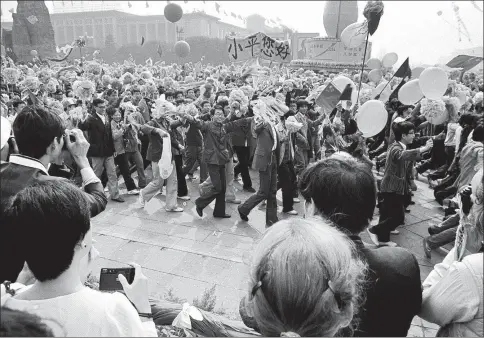  ?? HE YANGUANG / FOR CHINA DAILY ?? Students march with a banner bearing the words “Hello, Xiaoping” during the National Day parade in Beijing’s Tian’anmen Square on October 1, 1984.