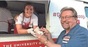  ?? FOUNDATION AND ALUMNI ASSOCIATIO­N TOD PRITCHARD / WISCONSIN ?? Madelyn Kordyban, program and event assistant with the Wisconsin Alumni Associatio­n, hands a scoop of ice cream to state Rep. Rick Gundrum, R-Slinger, at a “Music on Main” event in West Bend last month.
