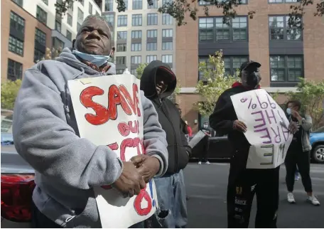  ?? PAUL CONNORS / BOSTON HERALD ?? ‘TALE OF TWO CITIES’: East Canton Street Associatio­n member Kenneth Woods, left, holds a sign during a rally against the neighborho­od high-rise on Saturday.