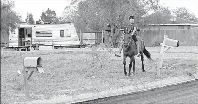  ?? AP/ERIC GAY ?? A boy rides through Indian Hills East colonia near Alamo, Texas, last month. Texas has more than 2,300 colonias that have sprung up around towns and are home to Hispanic immigrant families.