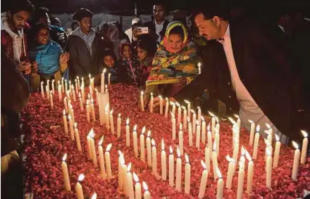  ?? AFP PIC ?? People lighting candles for victims of a suicide attack on a church in Quetta, Pakistan, on Friday.