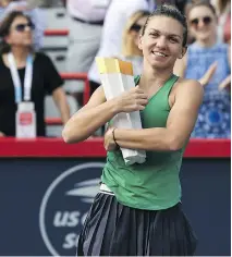  ?? MINAS PANAGIOTAK­IS/GETTY IMAGES ?? No. 1 seed Simona Halep of Romania hugs the Canada Open trophy after defeating third-seeded American Sloane Stephens 7-6, 3-6, 6-4 in the final day of the Rogers Cup Sunday in Montreal. Halep secured her victory with the fourth ace of the match.