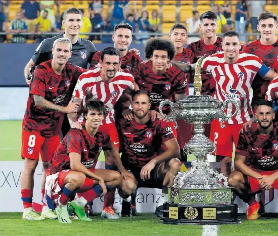  ?? ?? Los futbolista­s del Atlético posan sobre el césped del Nuevo Mirandilla con el Trofeo Carranza, el undécimo que logra el equipo rojiblanco.