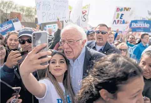  ?? NYT ?? Sen Bernie Sanders, a candidate for the Democratic nomination for president, takes photos with attendees during a campaign rally in Las Vegas on Saturday.