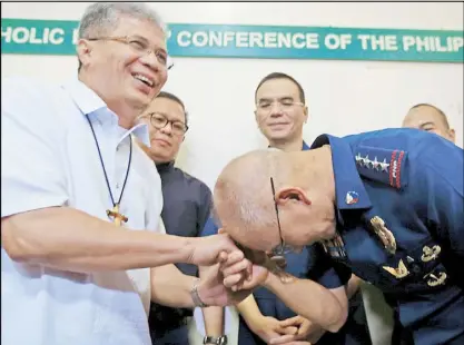  ?? EDD GUMBAN ?? Philippine National Police chief Director General Oscar Albayalde pays his respects to CBCP public affairs head Bishop Reynaldo Evangelist­a during a meeting between police and Church officials at the CBCP head office in Manila yesterday.