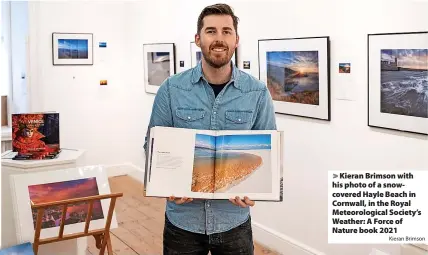  ?? Kieran Brimson ?? Kieran Brimson with his photo of a snowcovere­d Hayle Beach in Cornwall, in the Royal Meteorolog­ical Society’s Weather: A Force of Nature book 2021