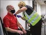  ??  ?? University of Dayton athletics employee Mark Gazdik gets a COVID-19 vaccinatio­n by Premier Health Nurse Midwife Susan Kloth. Premier Health vaccinated hundreds Monday at UD Arena.