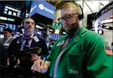  ?? RICHARD DREW — THE ASSOCIATED PRESS ?? Traders Gregory Rowe, left, and Ryan Falvey work on the floor of the New York Stock Exchange, Thursday.