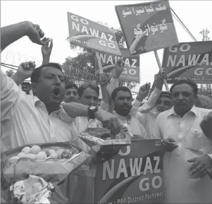  ?? MUHAMMAD SAJJAD, THE ASSOCIATED PRESS ?? Supporters of opposition parties share sweets to celebrate the dismissal of Pakistani Prime Minister Nawaz Sharif. When he was elected there were hopes Pakistan would grow closer to India and the West, crack down on terrorism and reform its economy.