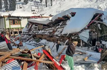  ?? AFP ?? AVALANCHE FURY: People remove debris of a collapsed house following heavy snowfall that triggered an avalanche in Neelum Valley in AJK on Tuesday. —