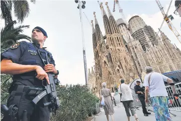  ??  ?? A police officer stands by the Sagrada Familia basilica in Barcelona, before a mass to commemorat­e victims of the two devastatin­g terror attacks in Barcelona and Cambrils. — AFP photo