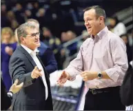  ?? Stephen Dunn / Associated Press ?? UConn coach Geno Auriemma, left, greets Louisville’s Jeff Walz before a 2018 game at Gampel Pavilion in Storrs. The teams announced on Friday they will play this season at Mohegan Sun Arena.