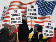  ?? BY DAVID ZALUBOWSKI AP FILE PHOTO ?? In this Feb. 11 file photo, teachers carry placards as they walk a picket line outside South High School in Denver. Oakland teachers say they will strike starting Thursday, Feb. 21.