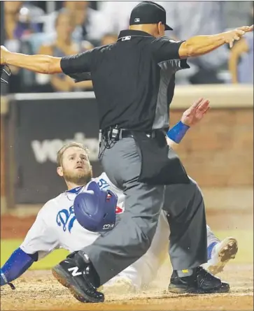  ?? Kathy Willens Associated Press ?? UMPIRE Vic Carapazza signals that the Dodgers’ Max Muncy is safe at home as he scored on Corey Seager’s fourth- inning single Sunday night. The Dodgers beat the Mets 3- 2 and took two of three games in the series.